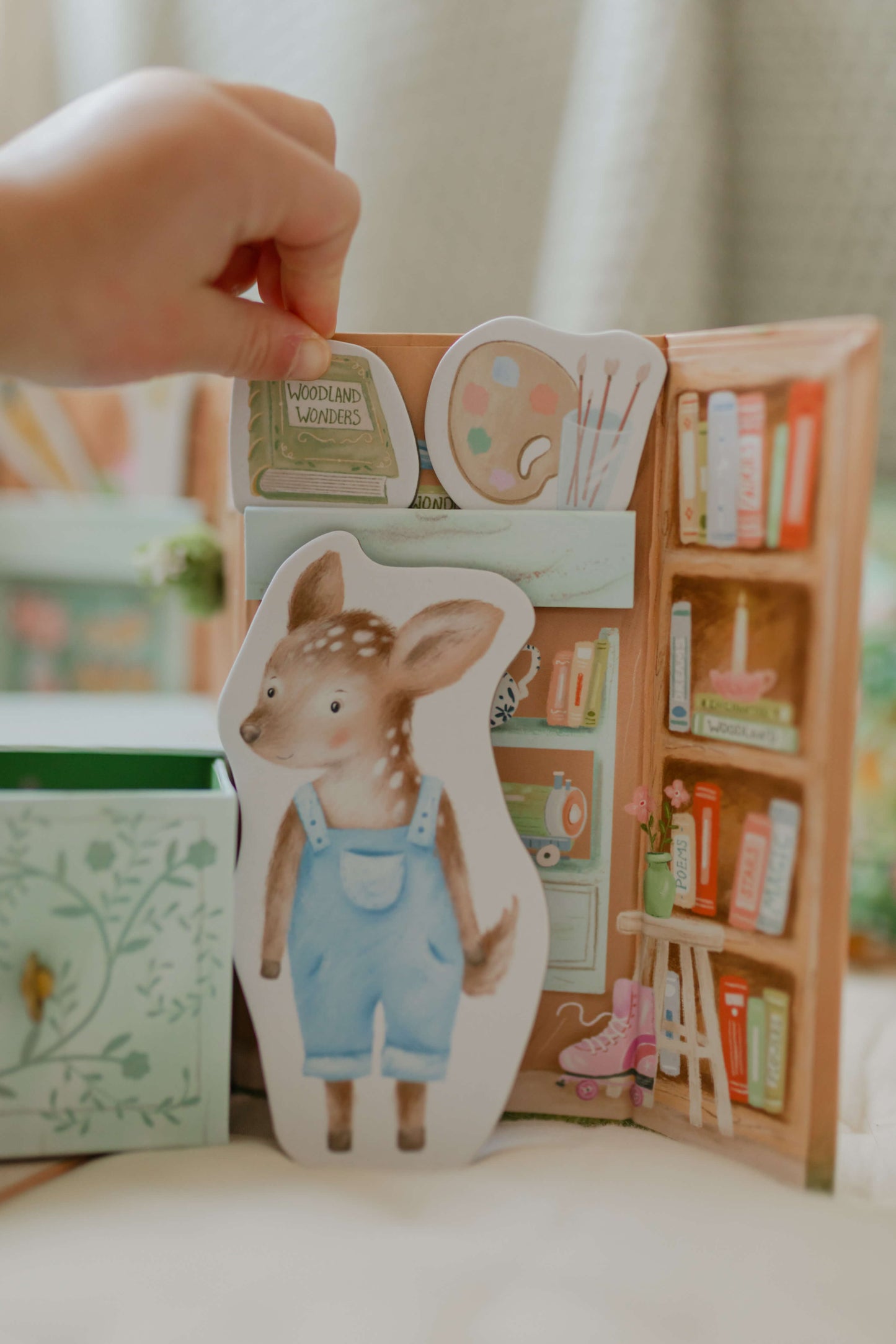 Child putting a book on a shelf inside the Woodland Shop with Dora Deer character.